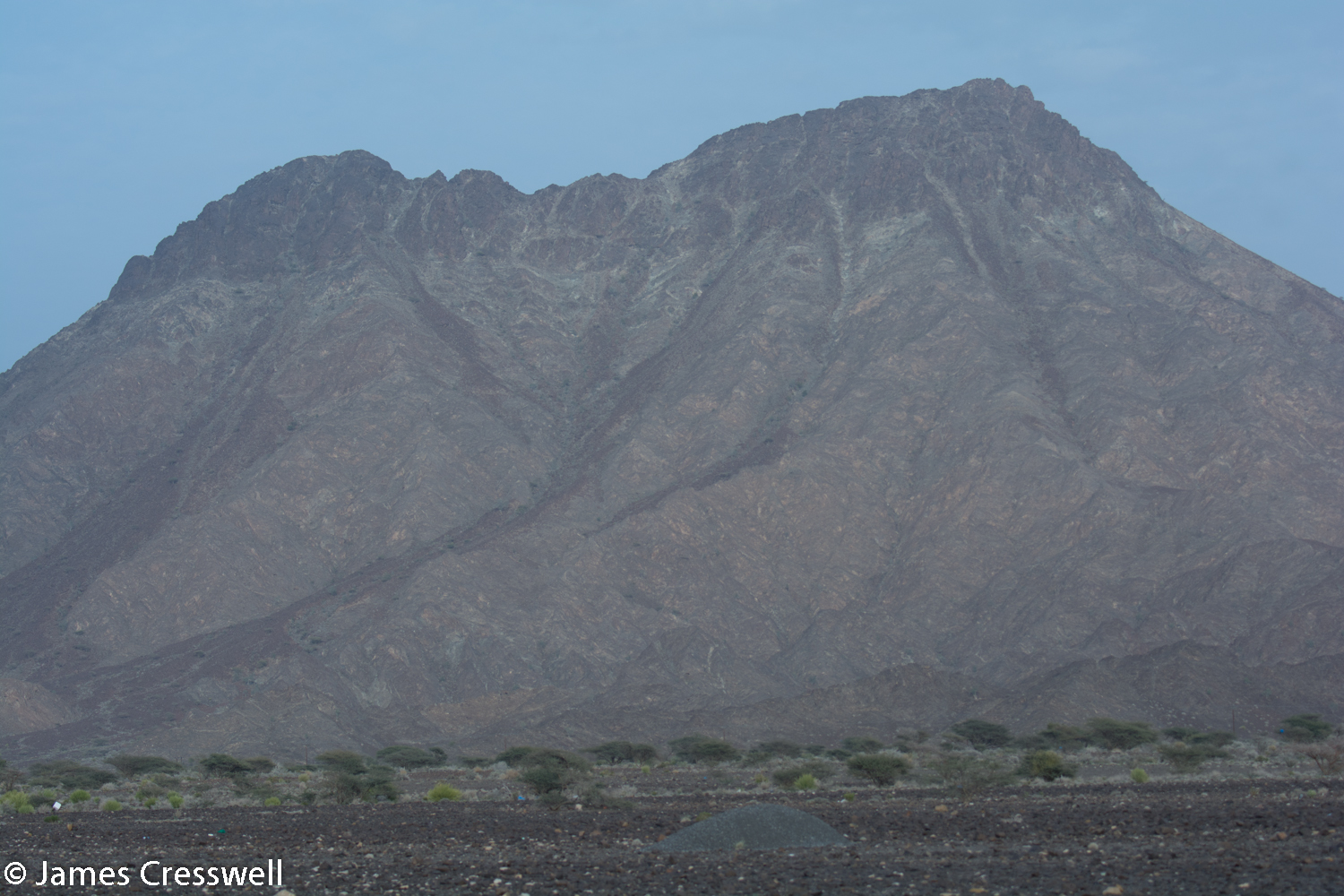 The Moho. Peridotite mountain capped with gabbro and the line of the Moho clearly visible.