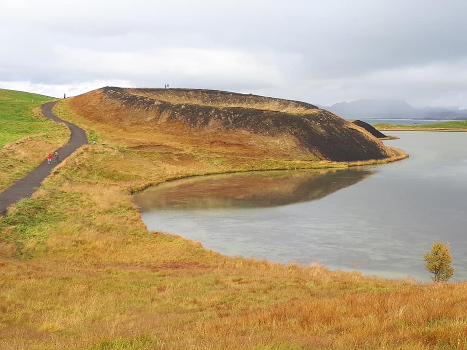 A rootless cone alongside a lake