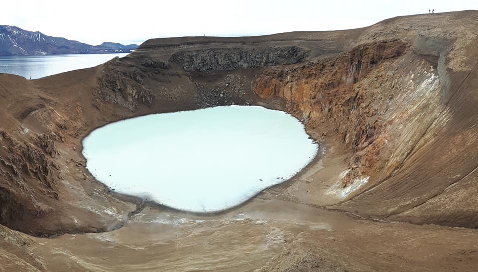 Volcanic crater filled with pale blue water