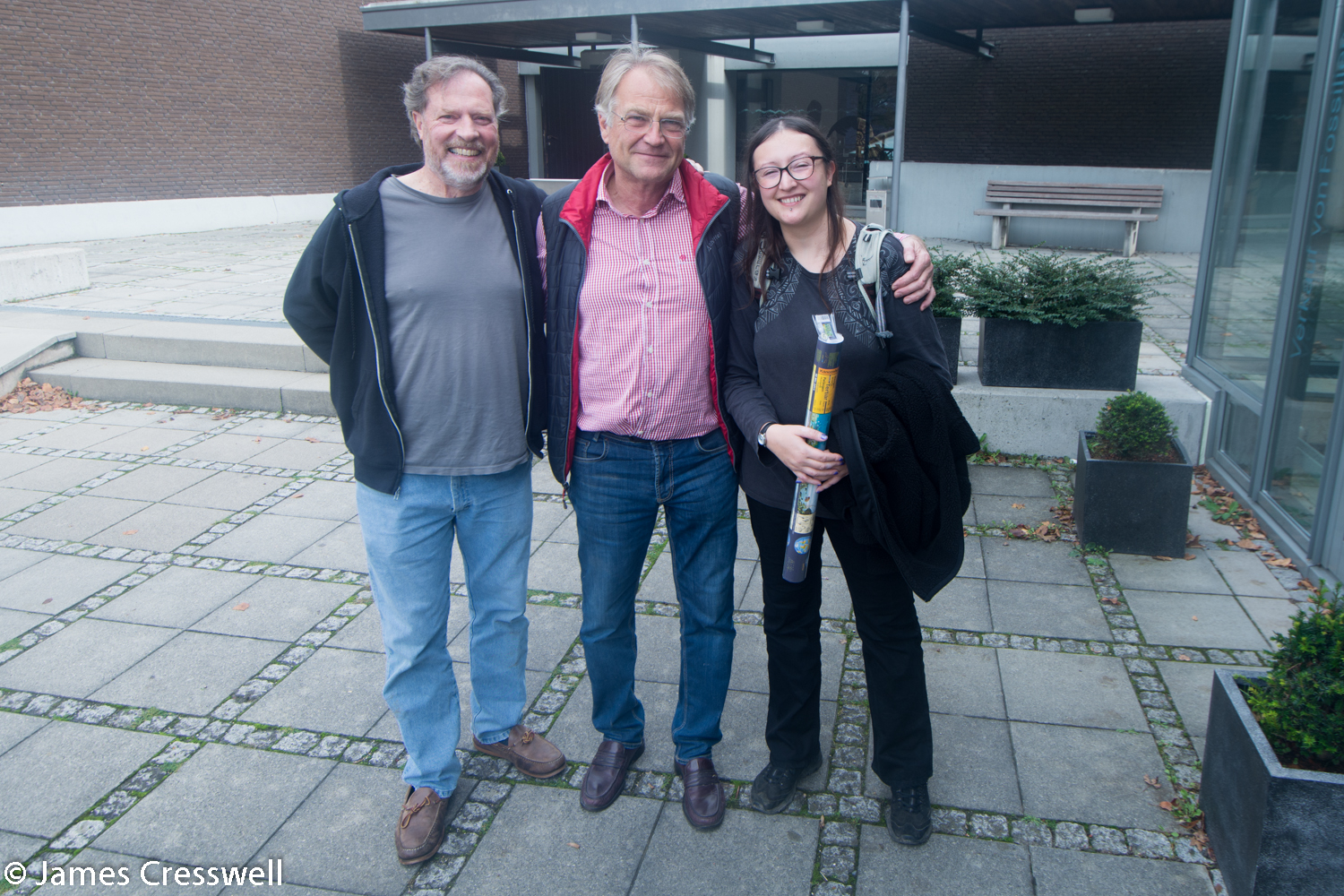 Three people outside museum
