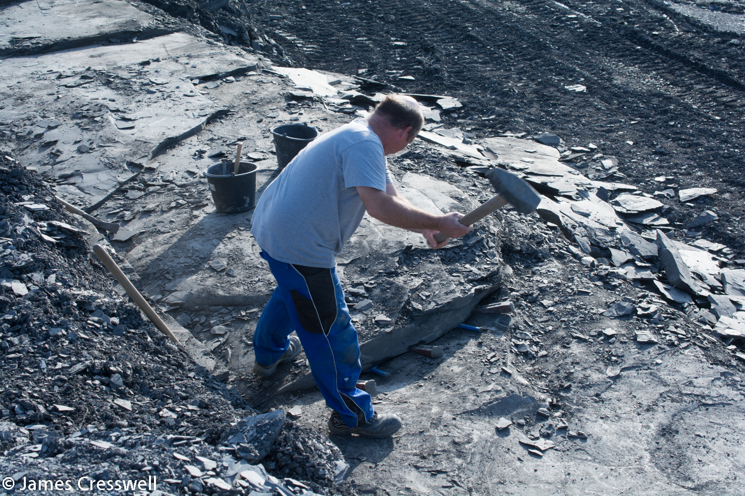 A quarryman splitting off some large slabs