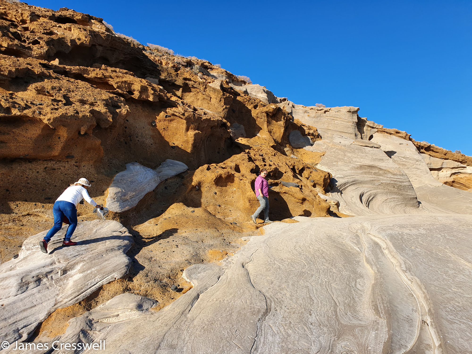Two people walking across fossilised beach dunes