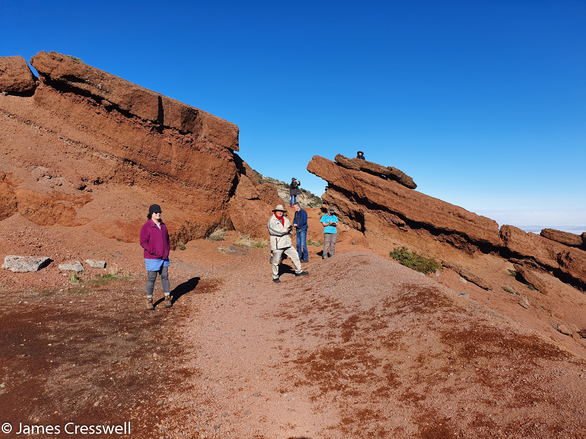 People standing in front of a rock formation