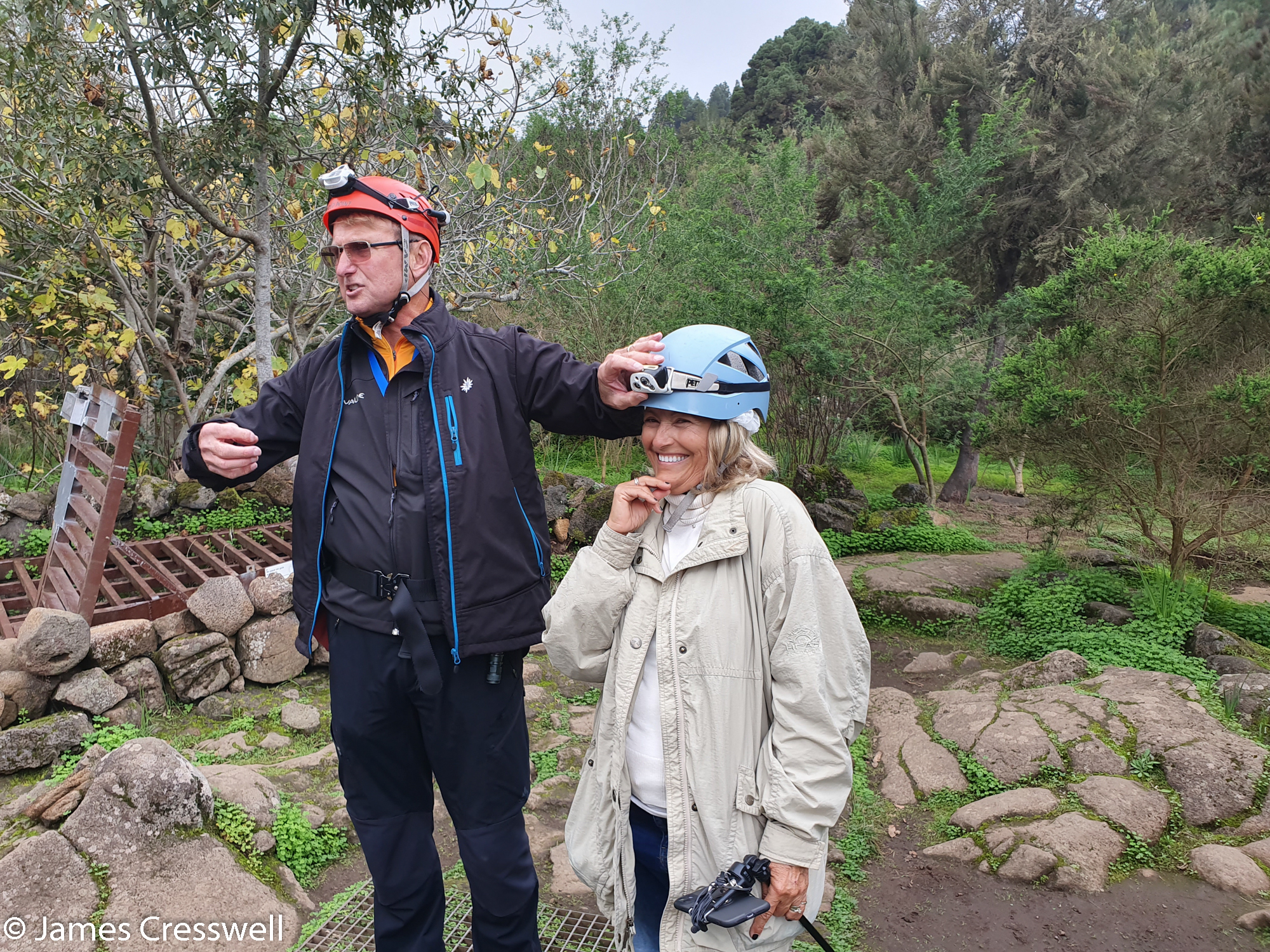 Man helping lady adjust her helmet light