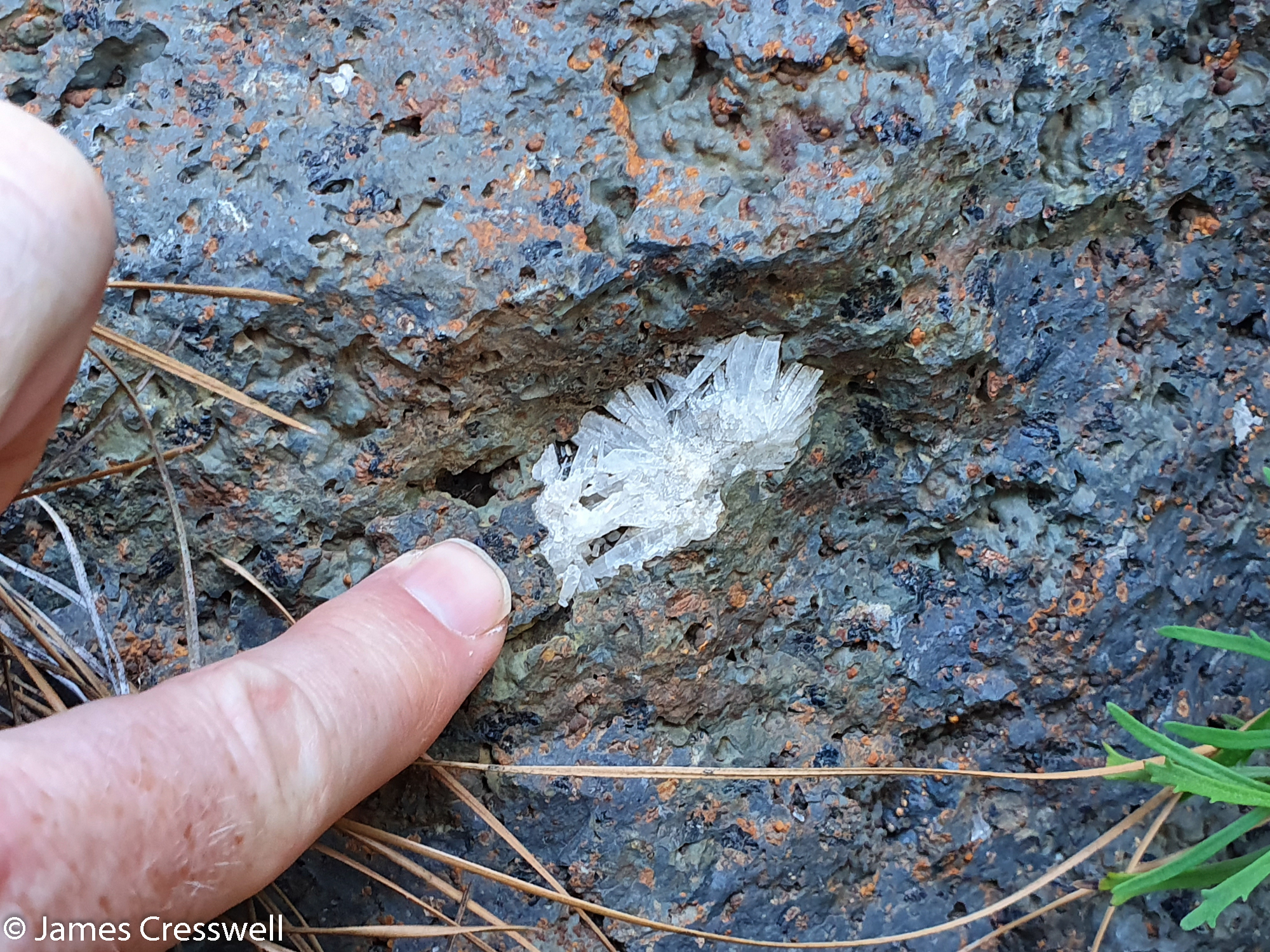 Finger pointing at a crystal deposit