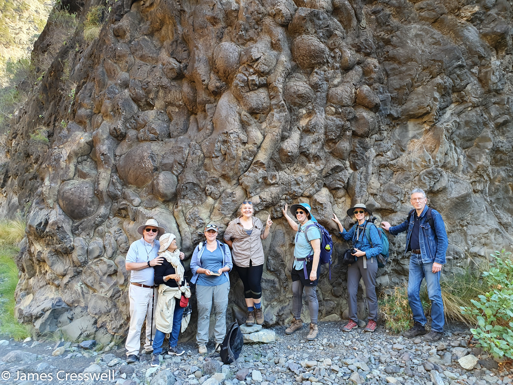 People standing in front of a rock face