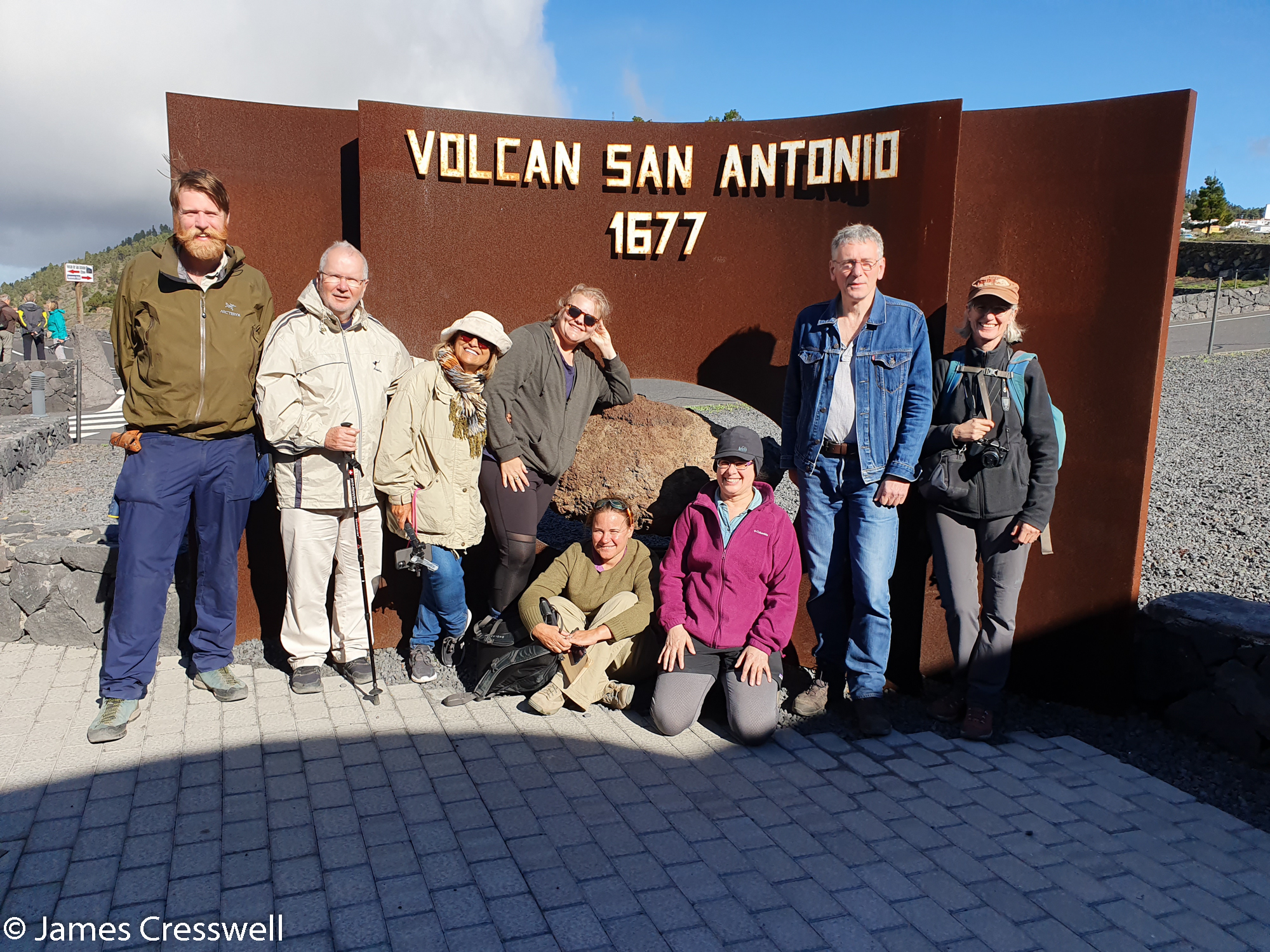 Group of people standing in front of metal sign