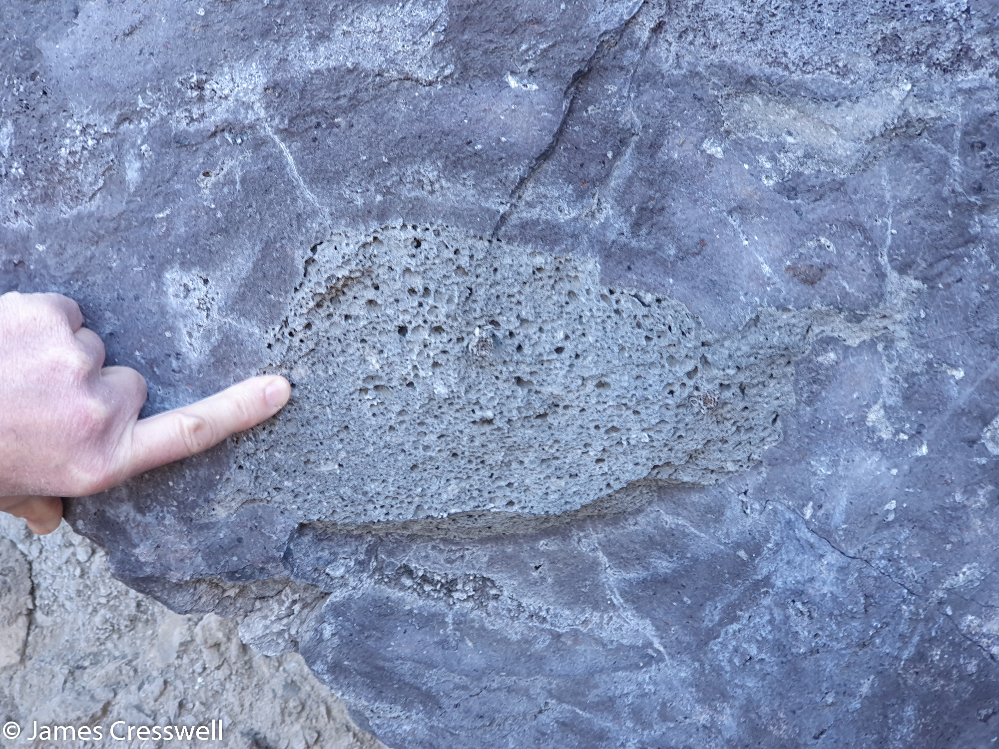 Finger pointing at a rock formation