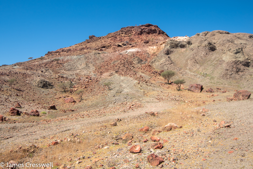 A photograph of a red coolured hill