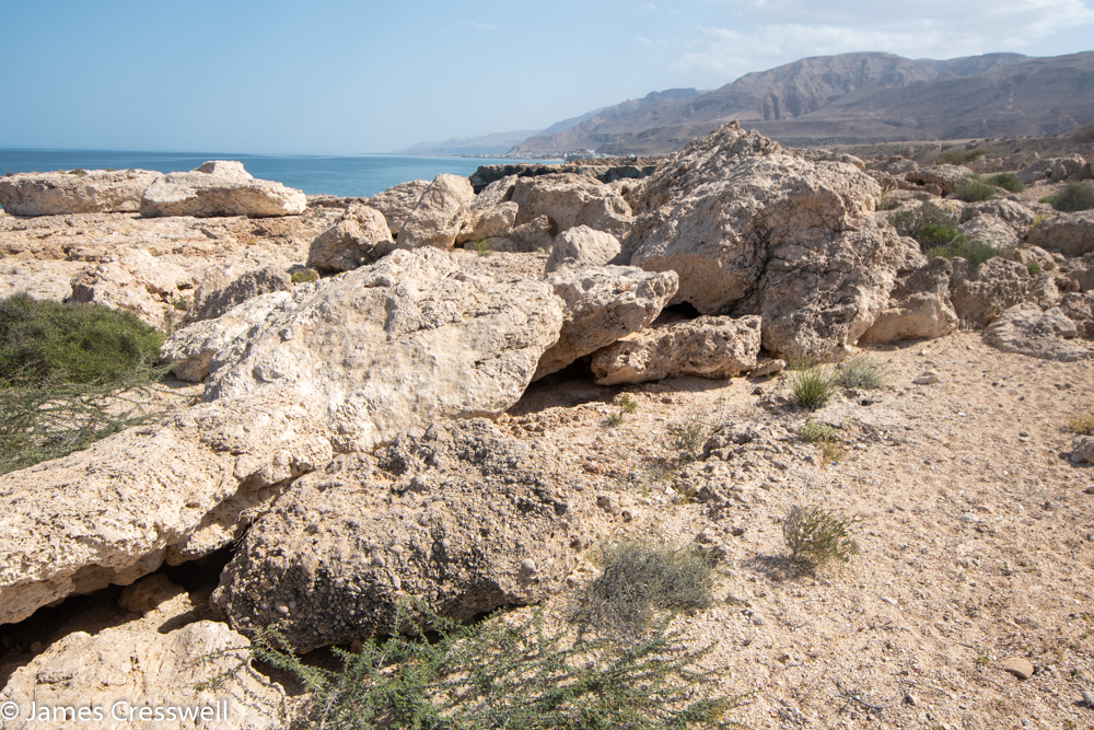 A photograph of a pile of large boulders stacked up on each other on a cliff top