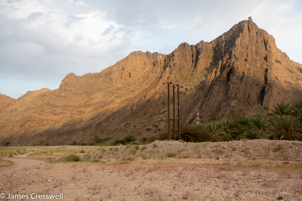 A photograph of a cliff with layers of rock the fold