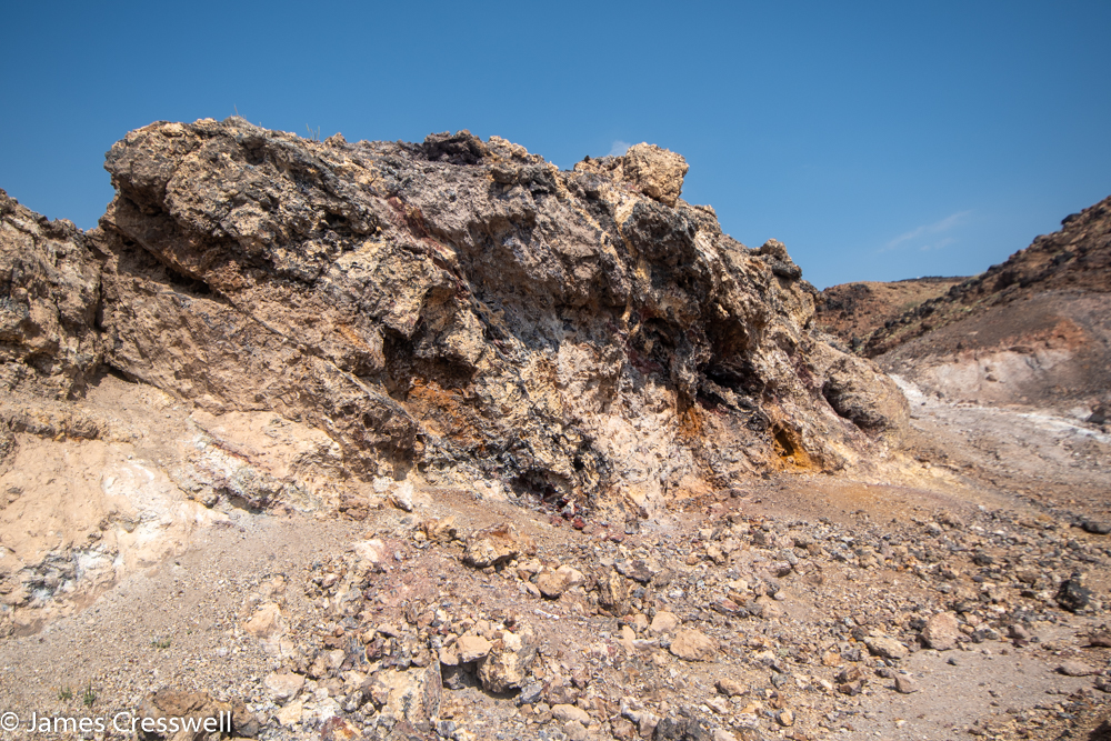 A photograph of a small rock cliff, that has bright white and orange colours