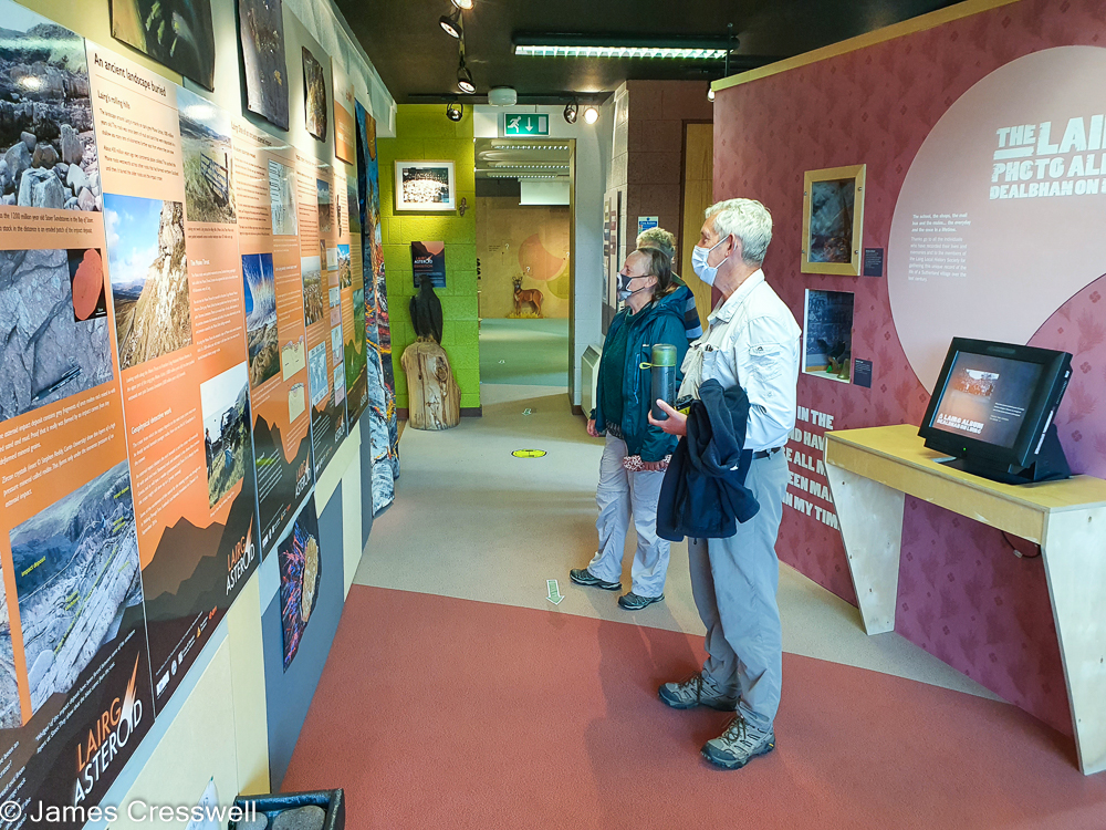 Three people read a notice board