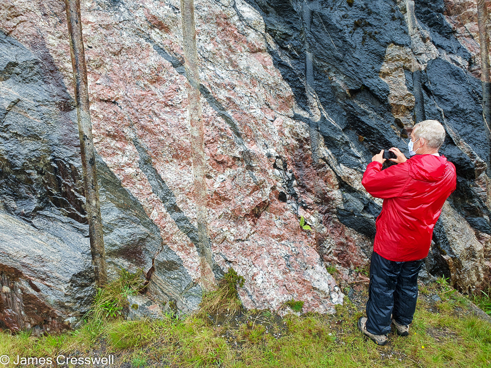 A man takes a photograph of colourful rocks