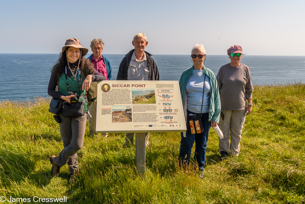 The 2021 GeoWorld Travel group standing next to the Siccar Point sign