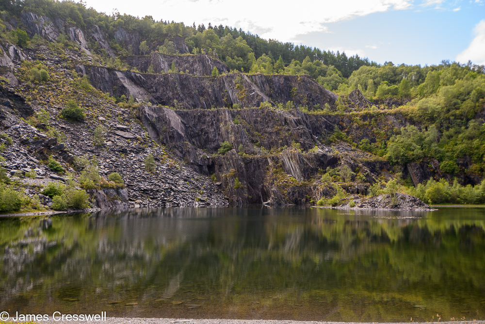 A pond with a quarry cliff face in the background