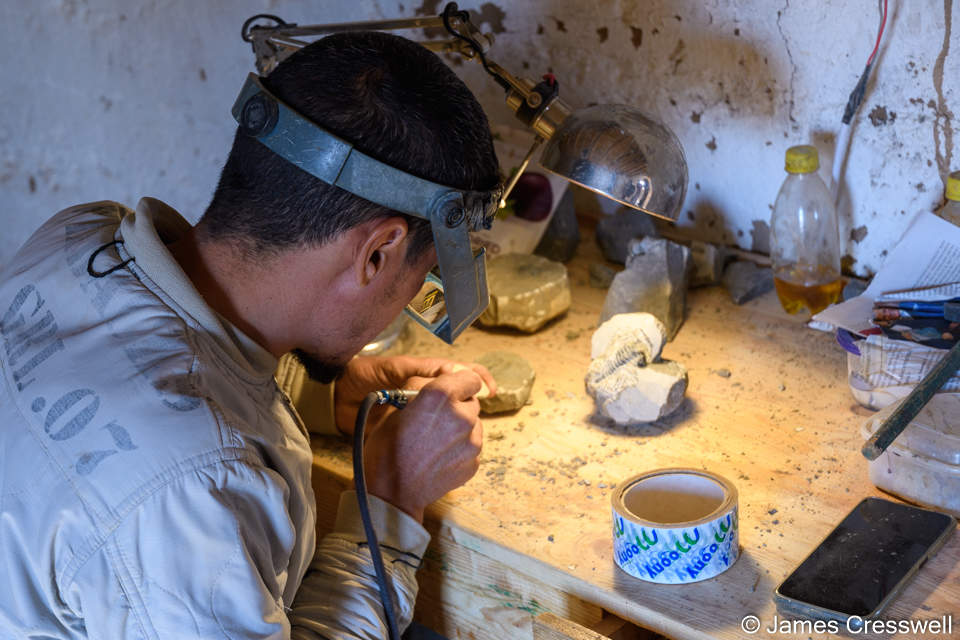 A fossil miner, the cousin of our driver, preparing a trilobite. Each fossil can take several weeks to extract from the rock.