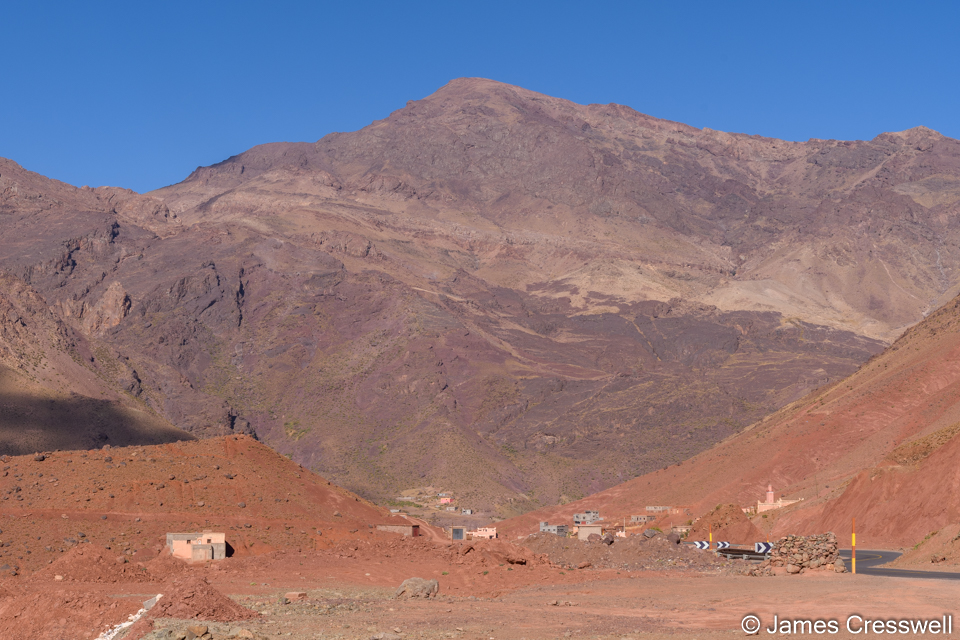 Crystalline Precambrian rock in the background with Triassic sedimentary rock in the foreground a fault runs between the two. In the High Atlas Mountains.