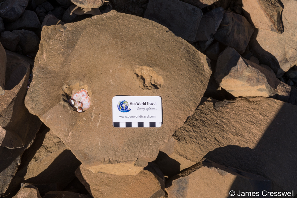 A block of basalt that cooled as a hexangal column that contains an agate, at the Sidi Rahaal mine.