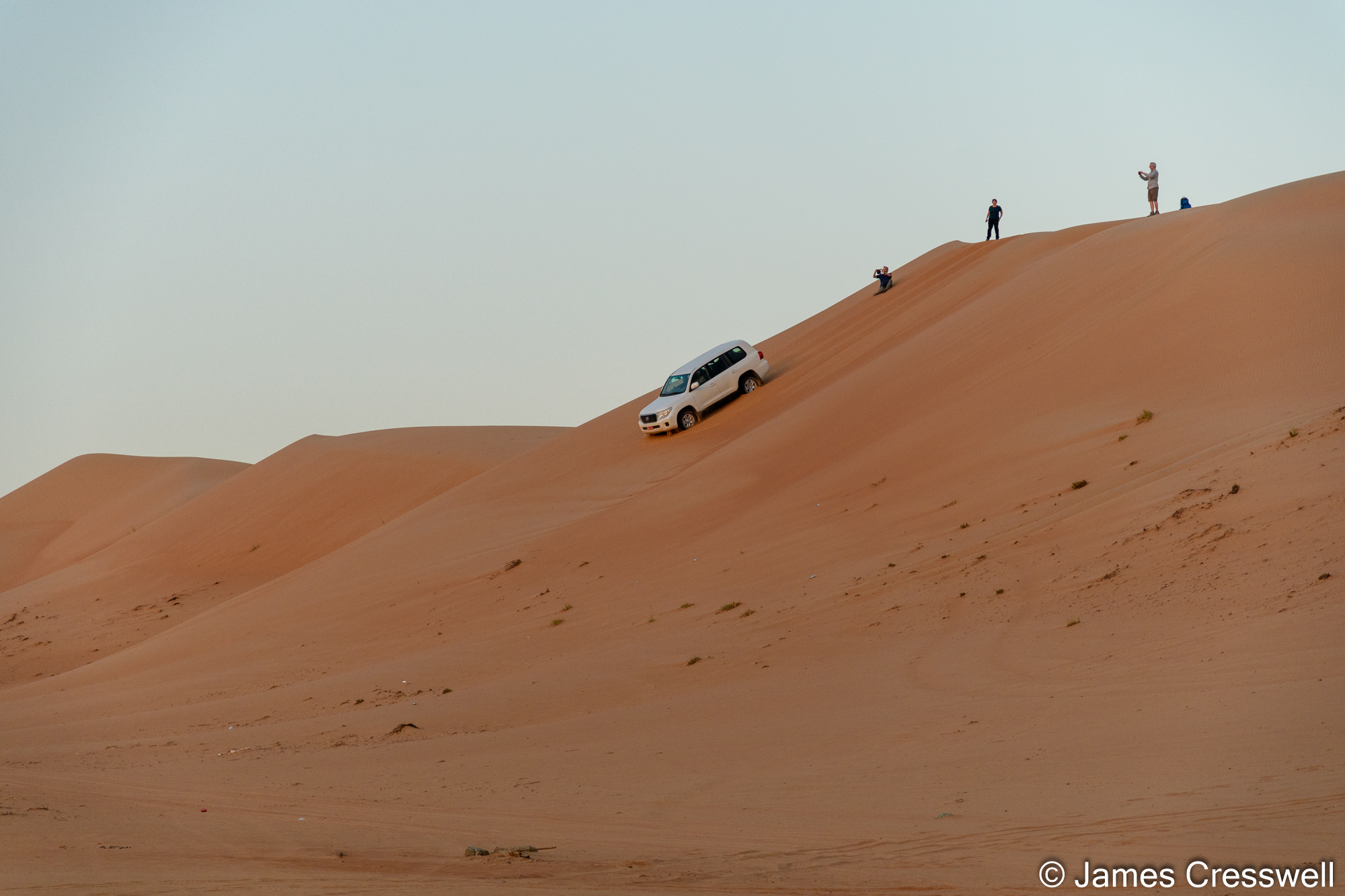 Vehicle driving down sand dunes