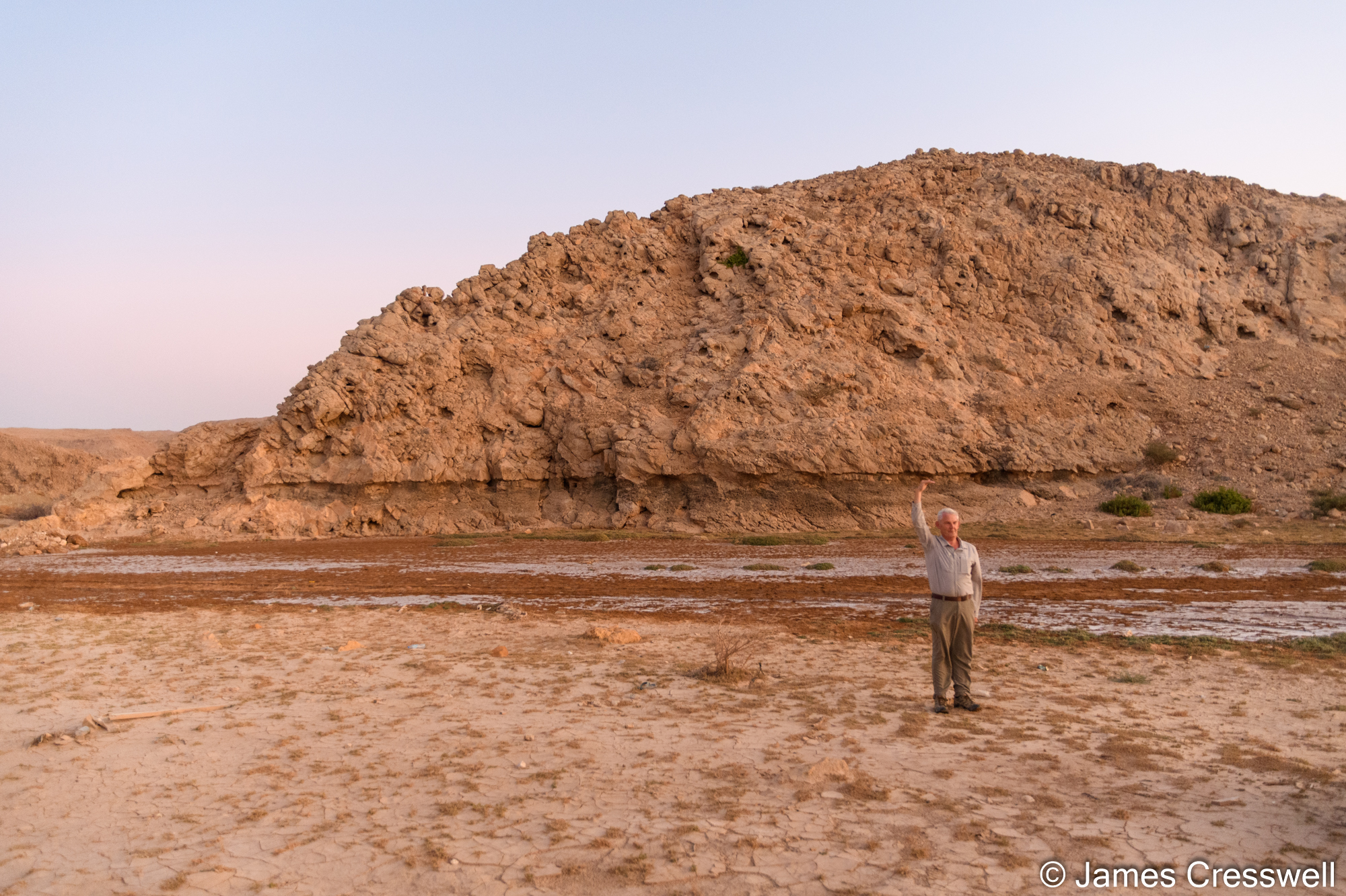 Man standing in front of rock