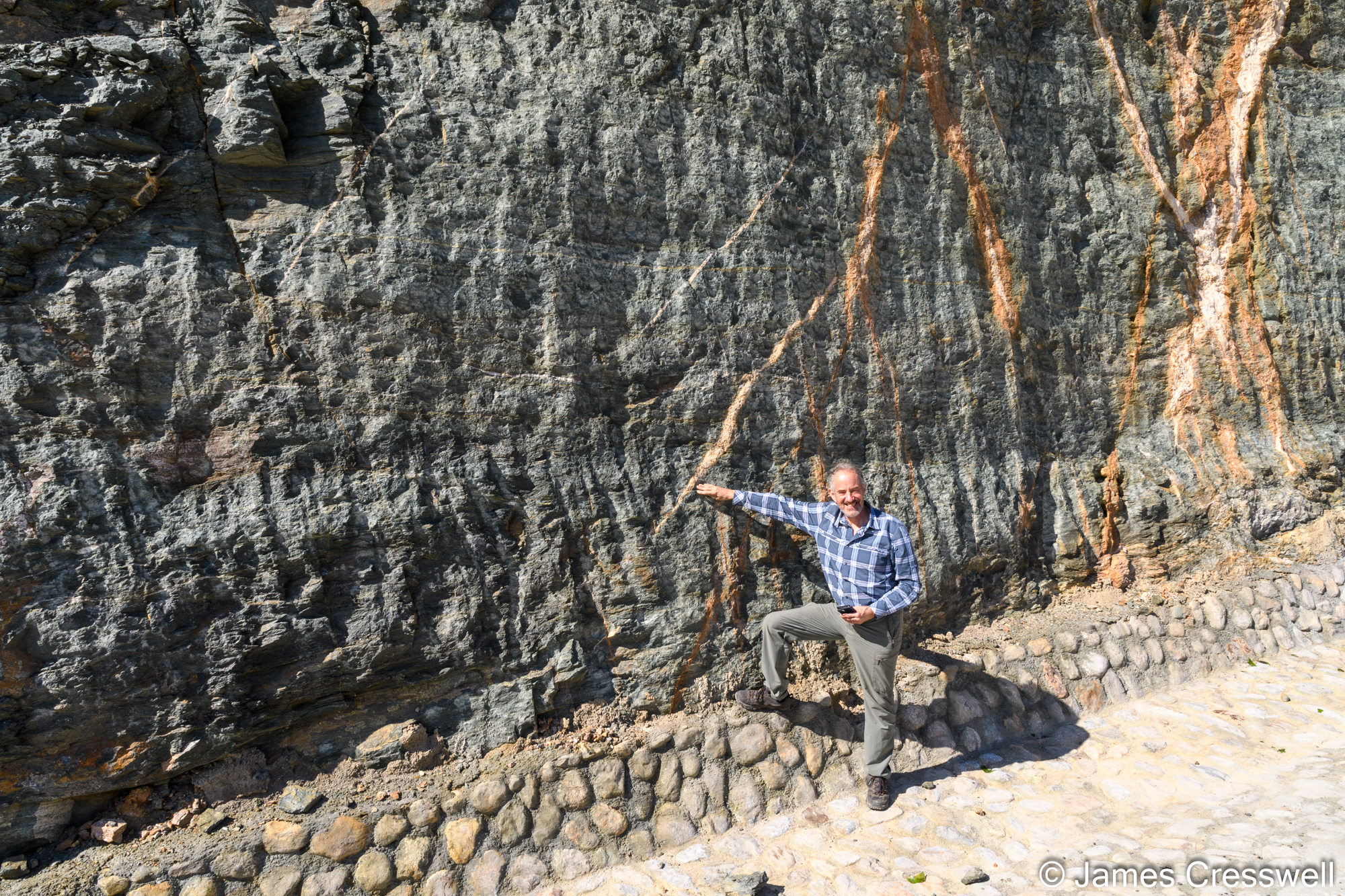 Man pointing to a rock outcrop