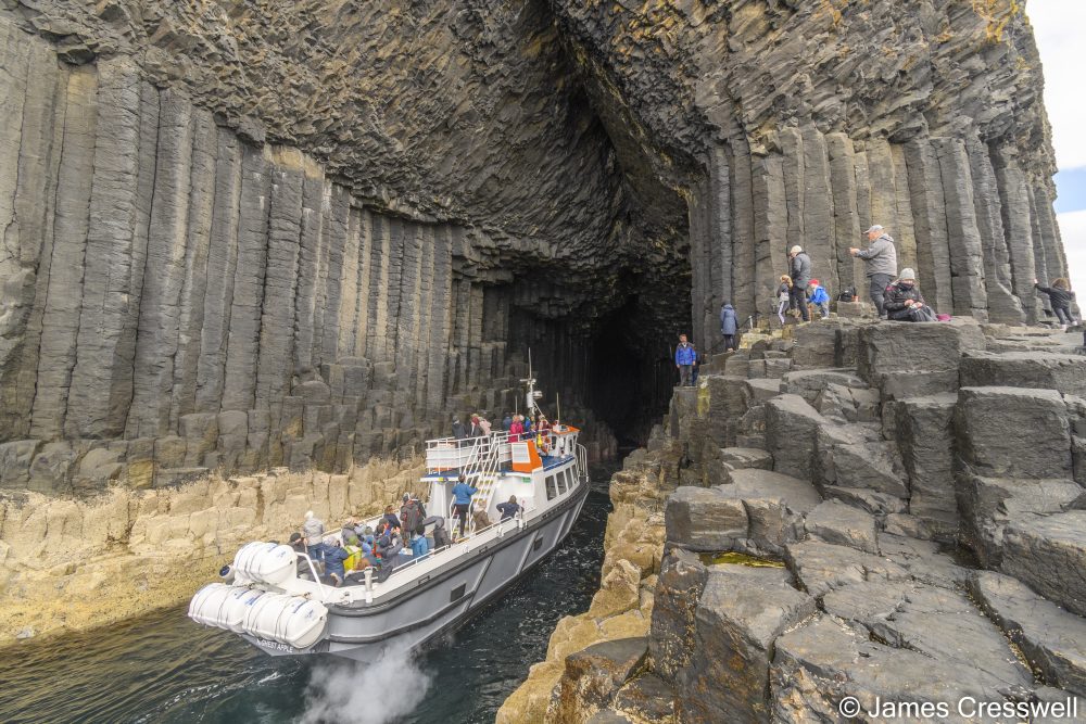 A boat in the entrance to a sea cave