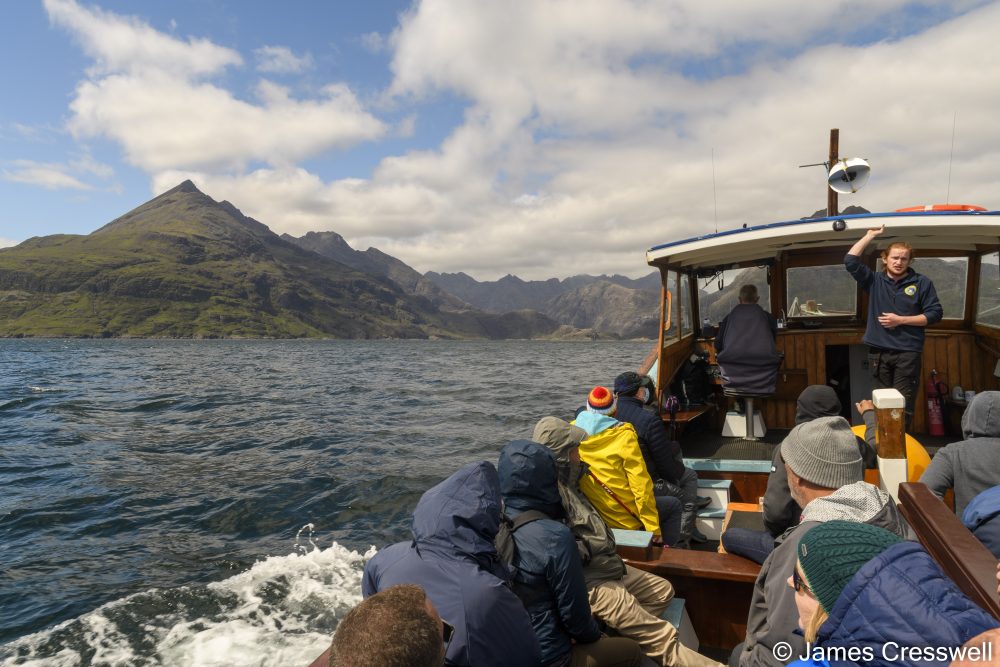 People on a boat with a mountain in the background