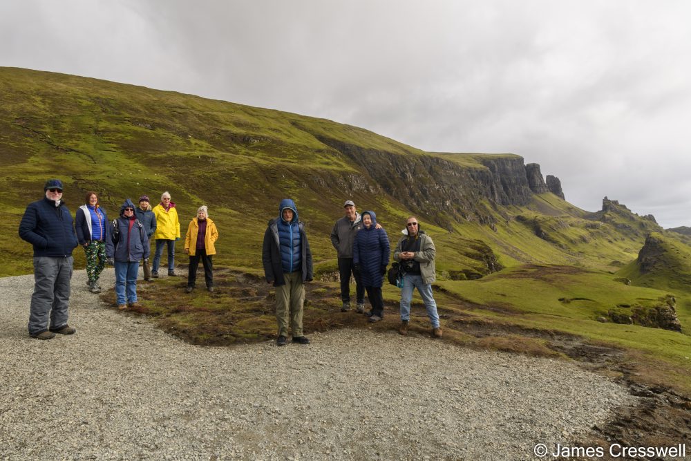 People standing in front of a hillside with landslip