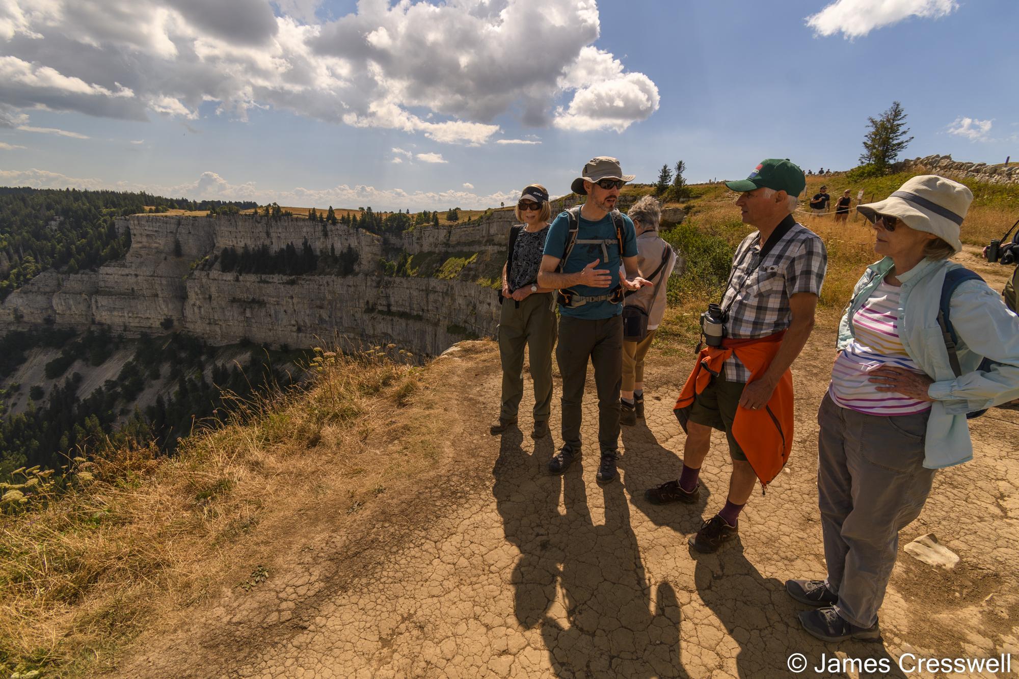 People standing by a cliff discussing