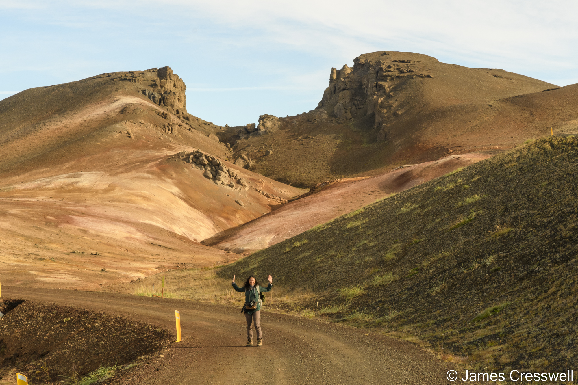 A woman standing in front a rocky landscape