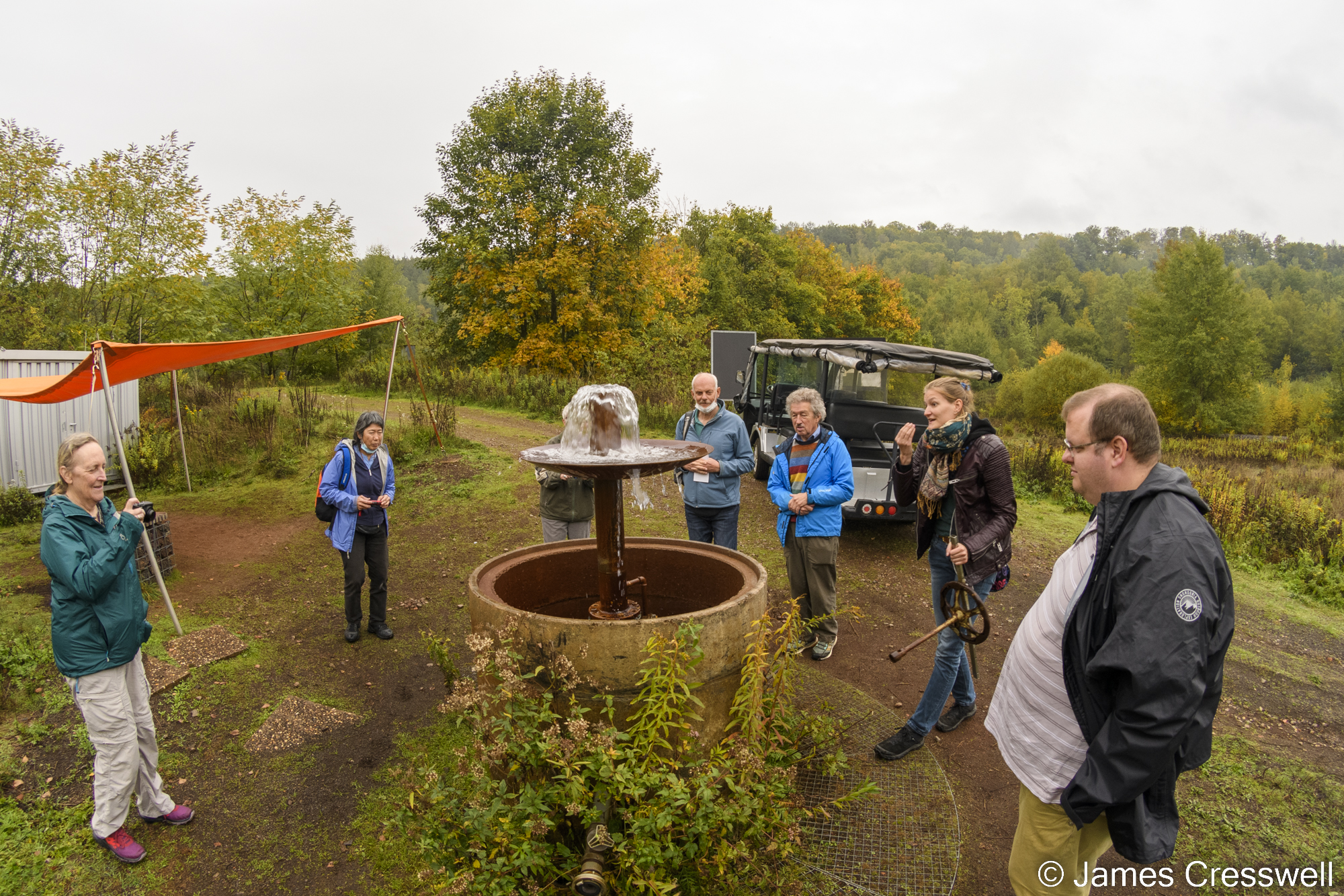 Group of people standing around a borehole