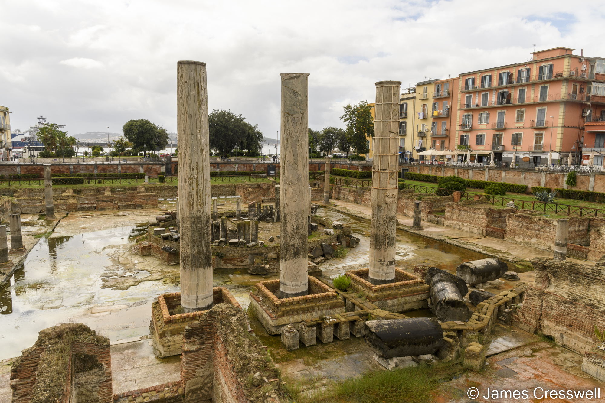Three pillars in the middle of some historical ruins