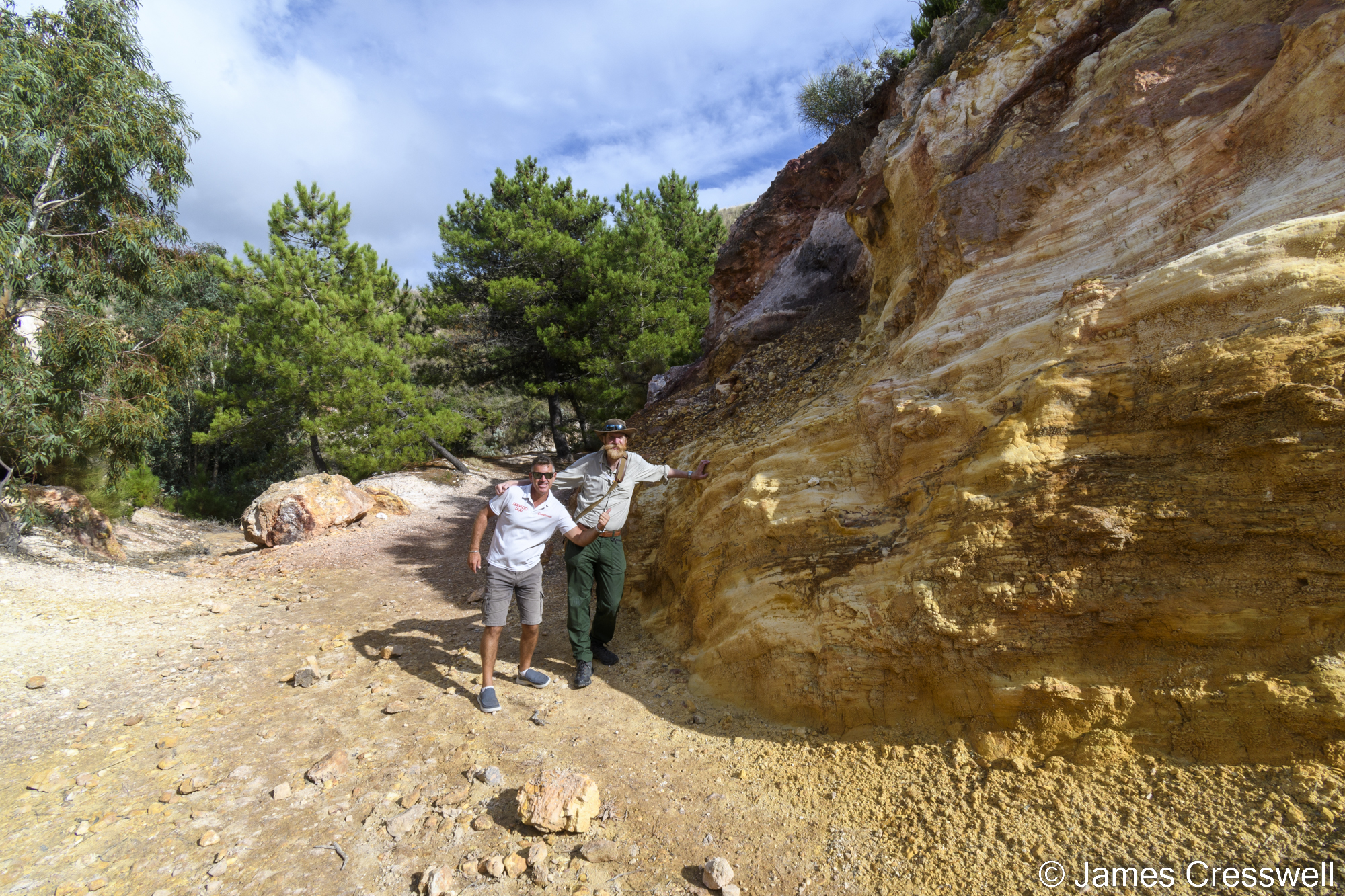 Two men standing by a rockface