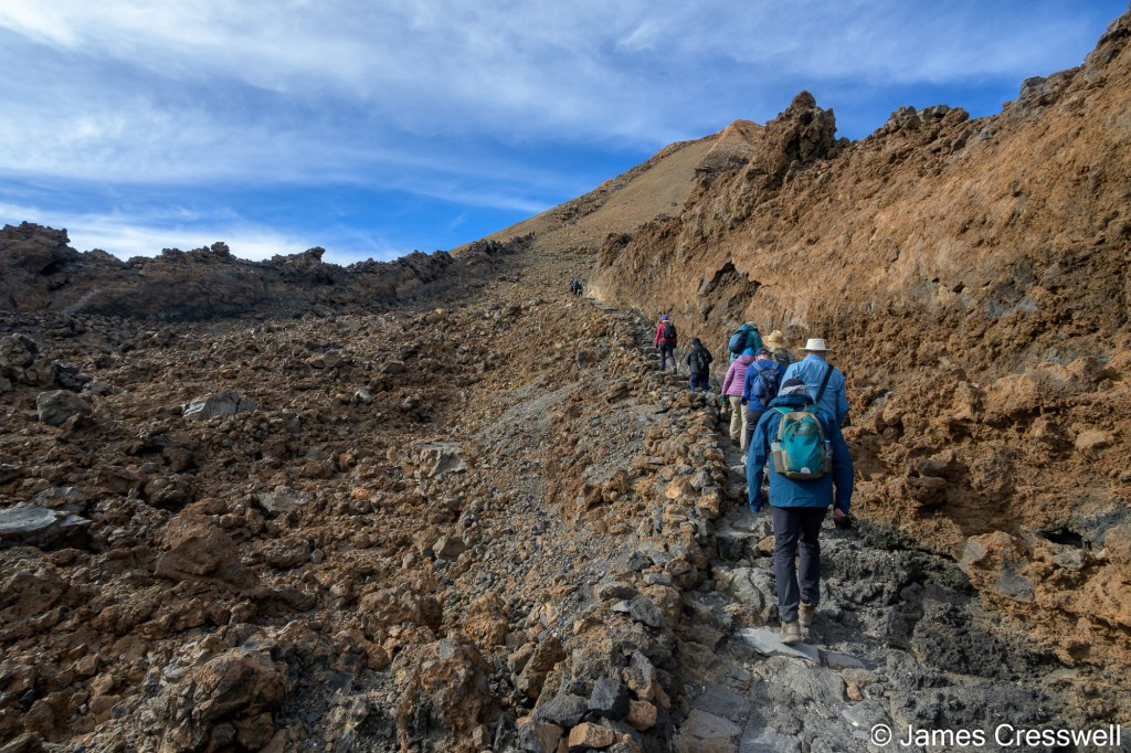 The GeoWorld Travel group starting the ascent to the summit of Mt Teide (at 3,718m) from the Upper Cable Car Station at 3,555m. The path leads across a phonolite lava flow.