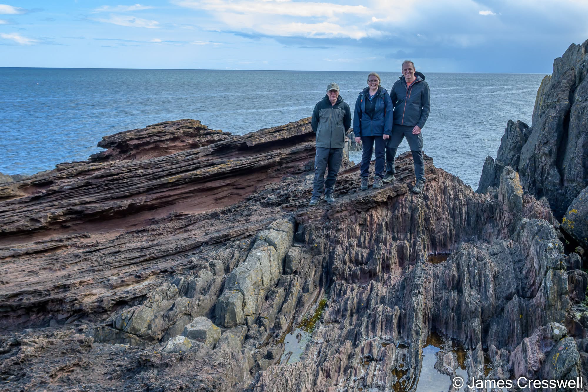 Torsten, Carol and Neil standing on Hutton's Unconformity at Siccar Point, arguably the world's most important geological site.